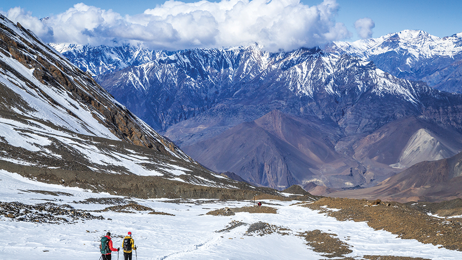 Wanderer beim Abstieg vom Thorun La in Nepal, dem höchsten Bergpass der Welt.