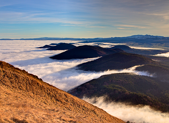 Die Vulkane der Auvergne durchstoßen die tief hängende Wolkendecke. © Pommeyrol Vincent / Shutterstock