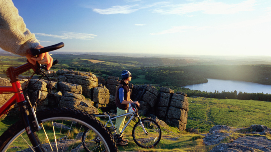 Biker machen Pause, um die grüne Landschaft Dartmoors auf sich wirken zu lassen. / © Peter Cade/Getty Images