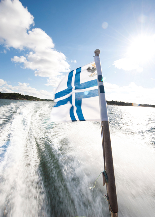 Finnische Flagge an einem Boot vor der Küste Turkus. © James Bedford