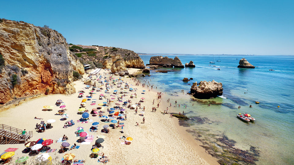 Kunterbunte Sonnenschirmparade: ein Badetag an der Praia Dona Ana - (Foto: ©DuMont Bildarchiv, Sabine Lubenow)