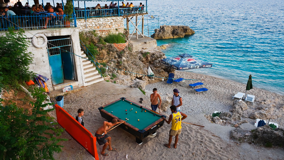 Die Strände von Dhermi laden tagsüber zum Entspannen ein, abends locken die Strandbars – (Foto: © Franz Aberham / Getty Images)