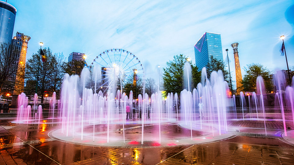 Bei Spaziergängern am Abend beliebt: der bunt beleuchtete Springbrunnen im Centennial Olympic Park mit dem Riesenrad im Hintergrund - (Foto: © Marilyn Nieves / Getty Images)