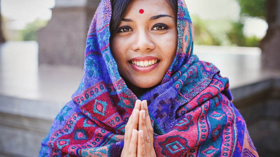 Das lächelnde Namaste hat die Bedeutung einer wertschätzenden Verneigung - (Foto: ©LiudmylaSupynska/Getty Images)