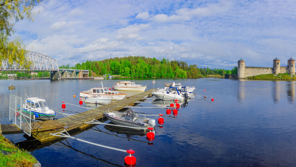 Idyllisch liegen die Boote vor der Burg Olavinlinna aus dem 15. Jahrhundert in Savonlinna im Wasser - (Foto: © RnDmS / Shutterstock)