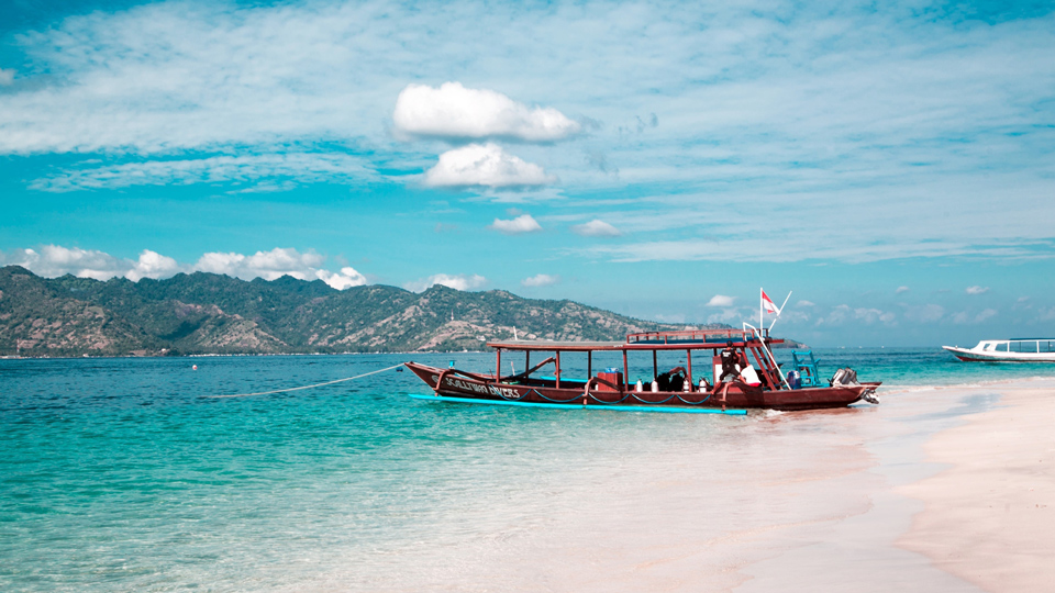 Ein rotes Boot legt im kristallklaren Wasser von Gili Trawangan - (Foto: ©juliyaburnos/Shutterstock)