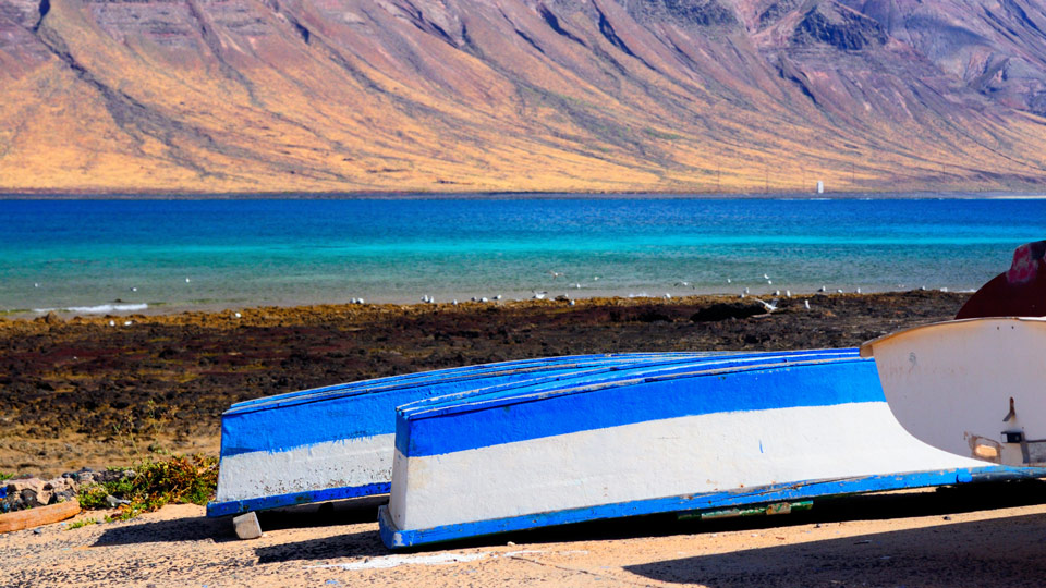 Fischerboote auf La Graciosa, im Hintergrund die Klippen von Lanzarote - (Foto: © anyaivanova / Shutterstock)