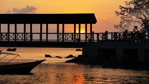 Pier und Boote im Sonneuntergang bei den Perhentian Islands. - (Foto: ©Alex/500px Royalty Free)