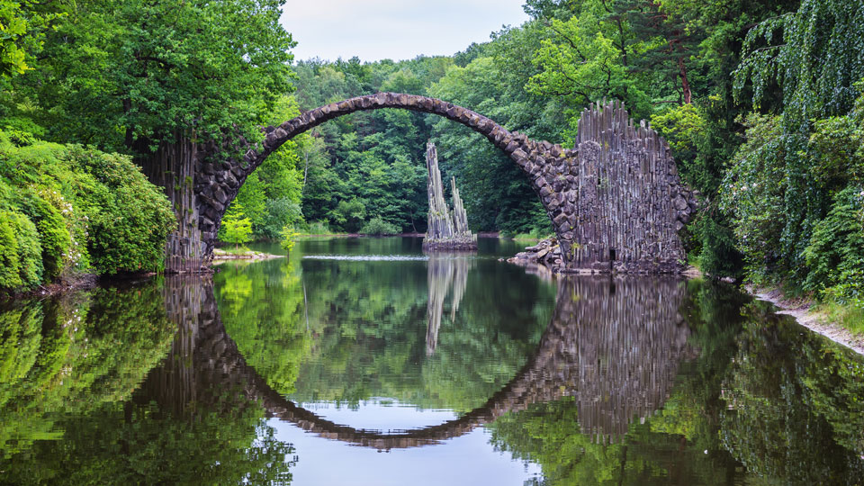 Die Spiegelung der Rakotzbrücke im Wasser, die auch als Teufelsbrücke bekannt ist, ergibt einen Kreis - (Foto: © DaLiu / Shutterstock)