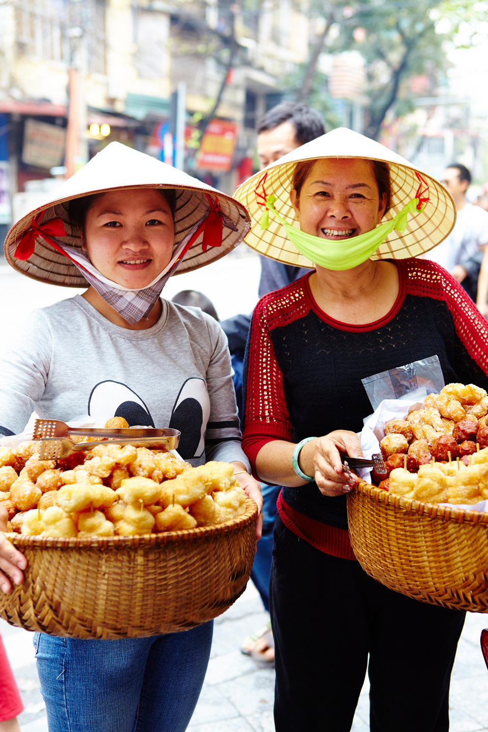 Zwei Frauen mit Streetfood in Hanoi. Ein paar Brocken Vietnamesisch zu sprechen, ist der Schlüssel zu den Menschen, egal ob an den Straßenständen in der Stadt oder beim Wandern im Hochland - (Foto: © Matt Munro/Lonely Planet)