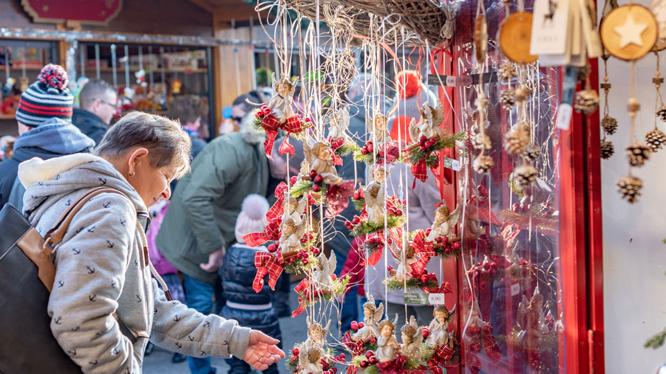 Die Stände regionaler Künstler und Kunsthandwerker laden in Innsbruck vor der Kulisse der verschneiten Alpen zum Stöbern und Kaufen ein - (Foto: © KlavdiyaV / Shutterstock)