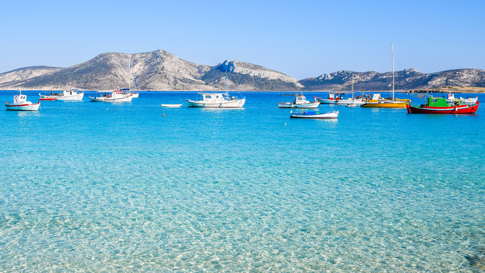 Traditionelle Fischerboote ankern im seichten Wasser vor Koufonisia, der bekanntesten Insel der Kleinen Kykladen © Nicole Kwiatkowski / Shutterstock